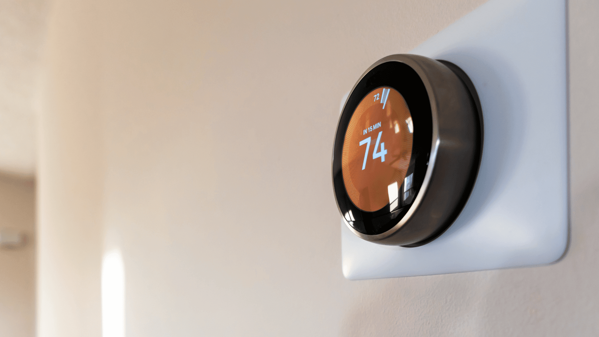 Smart thermostat on wall displaying '74°F'